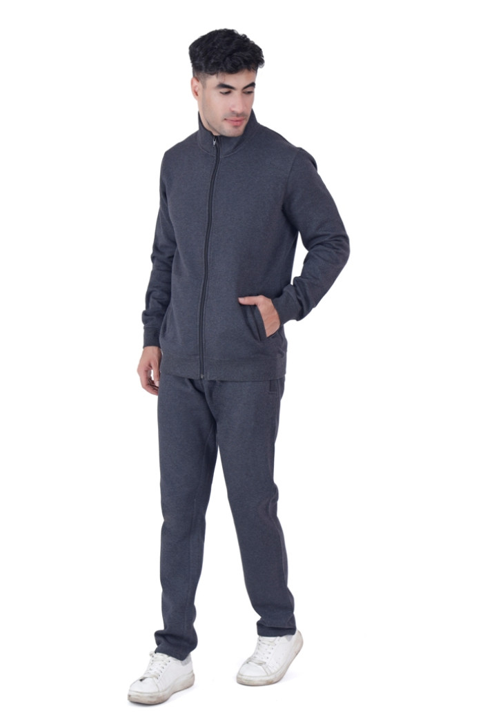 A man dressed in Coatsnmore’s Super Anthra full-zip tracksuit with a stand-up collar, posing casually with one hand in his jacket pocket and the other relaxed by his side, wearing white sneakers against a white background.